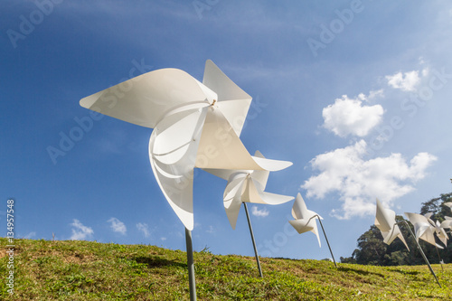 Valokuva White pinwheel and windmill with blue sky and white cloud background, symbol of