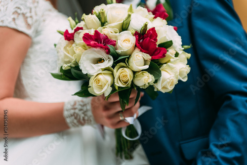white and red bouquet in bride hands