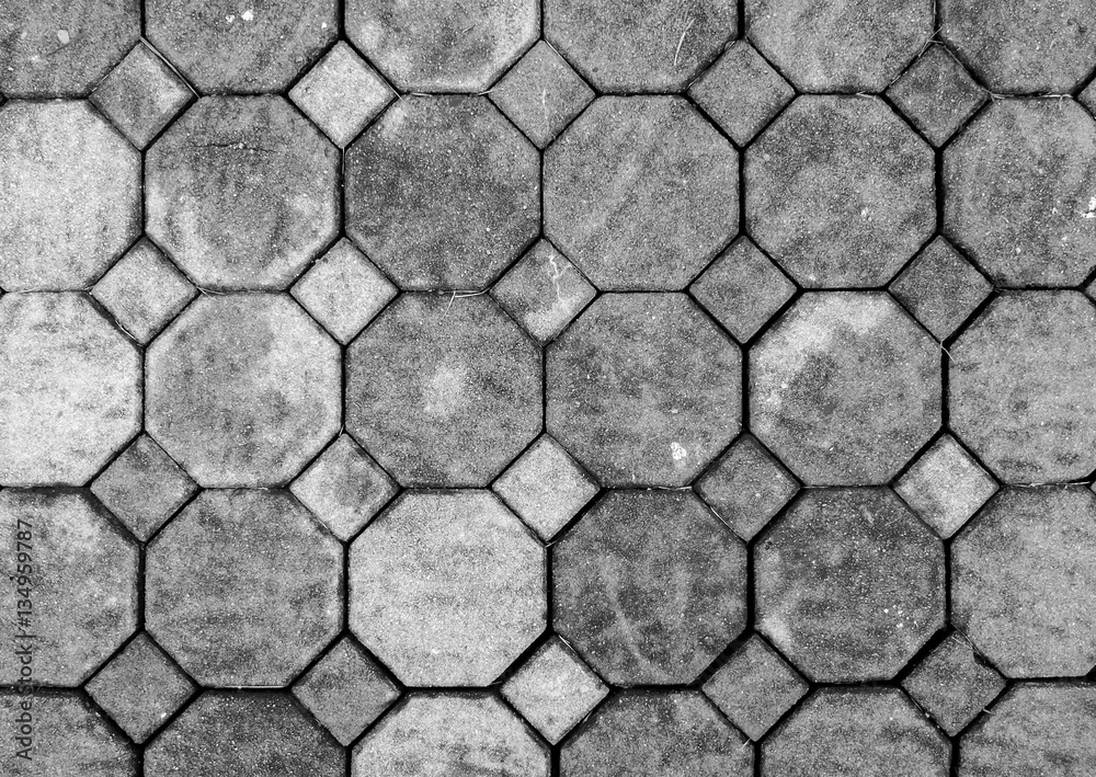Fototapeta premium Top View of Monotone Grunge Gray Brick Stone on The Ground for Street Road. Sidewalk, Driveway, Pavers, Pavement in Vintage Design Flooring Hexagon Pattern Texture Background