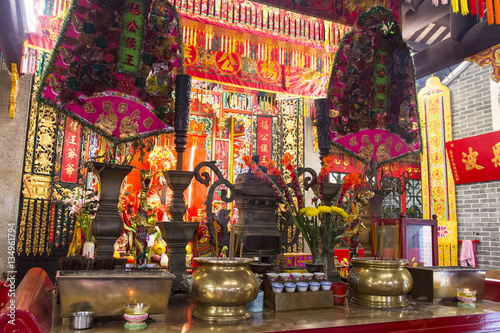 Holy statues and the offers on the altar in Yeung Hau temple in Tai O village, Hong Kong.