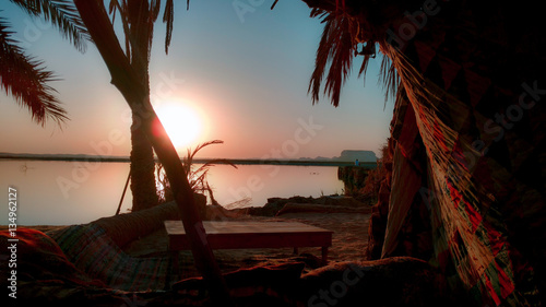 Sitting by a lake watching the sunset at the beautiful Fetnas island in Siwa Oasis, Egypt