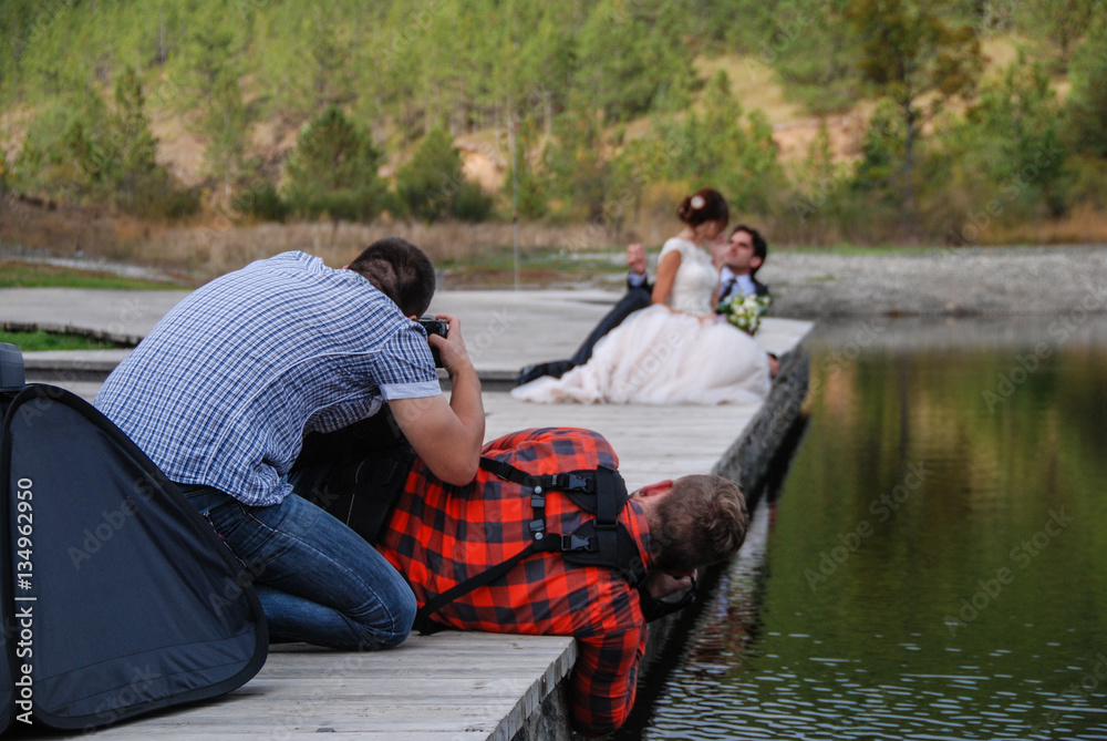 Photographers shooting a wedding by the river Photographers shooting a wedding by the river