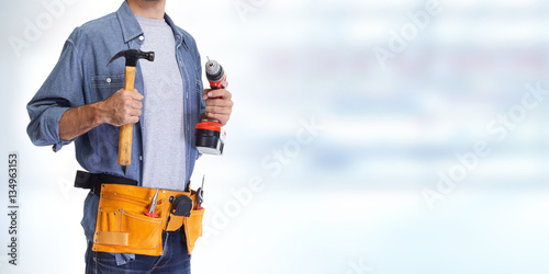 Builder handyman with drill and hammer.