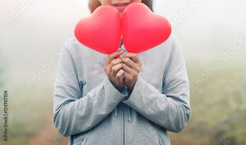 Fototapeta Naklejka Na Ścianę i Meble -  Asian woman holding red hearts