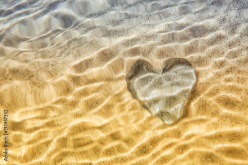 Foto Heart distortion under water, blurred wave action over glass hea