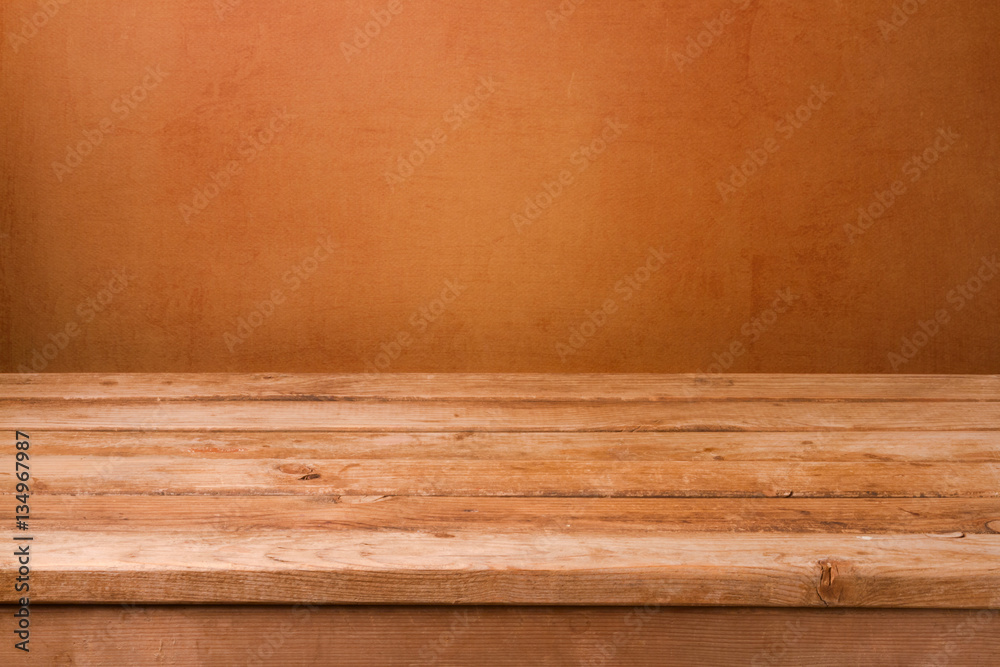 Empty wooden deck table over brown rustic wall background for product montage display Empty wooden deck table over brown rustic wall background for product montage display