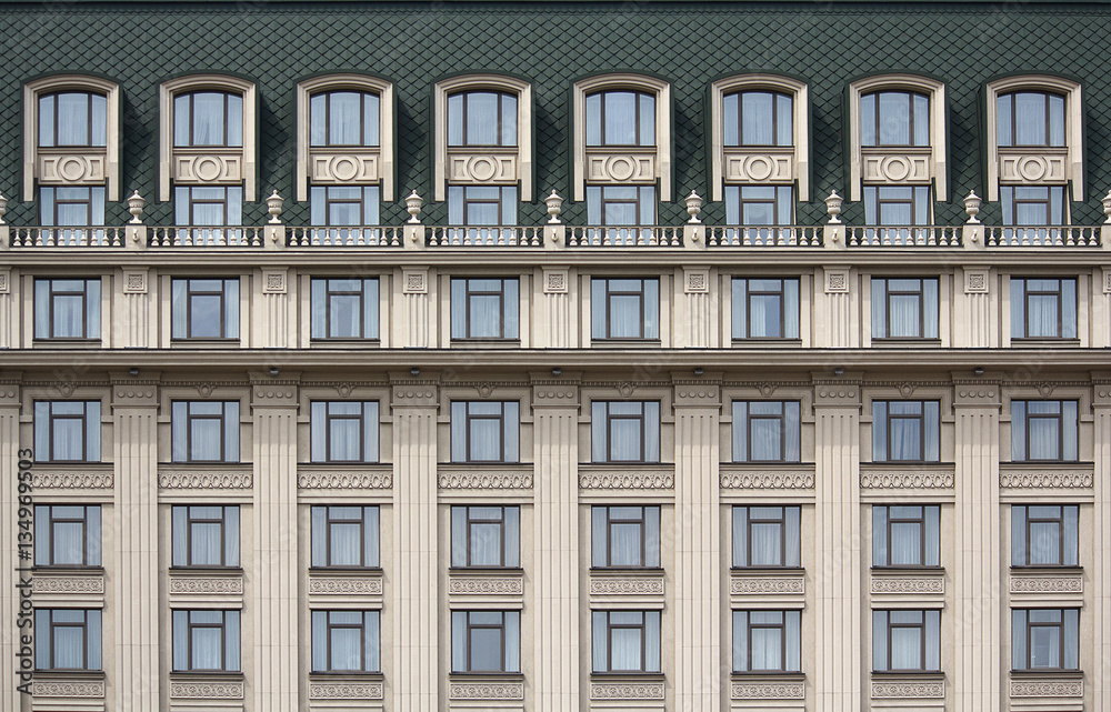 Several windows in a row on the facade of the building in classi
