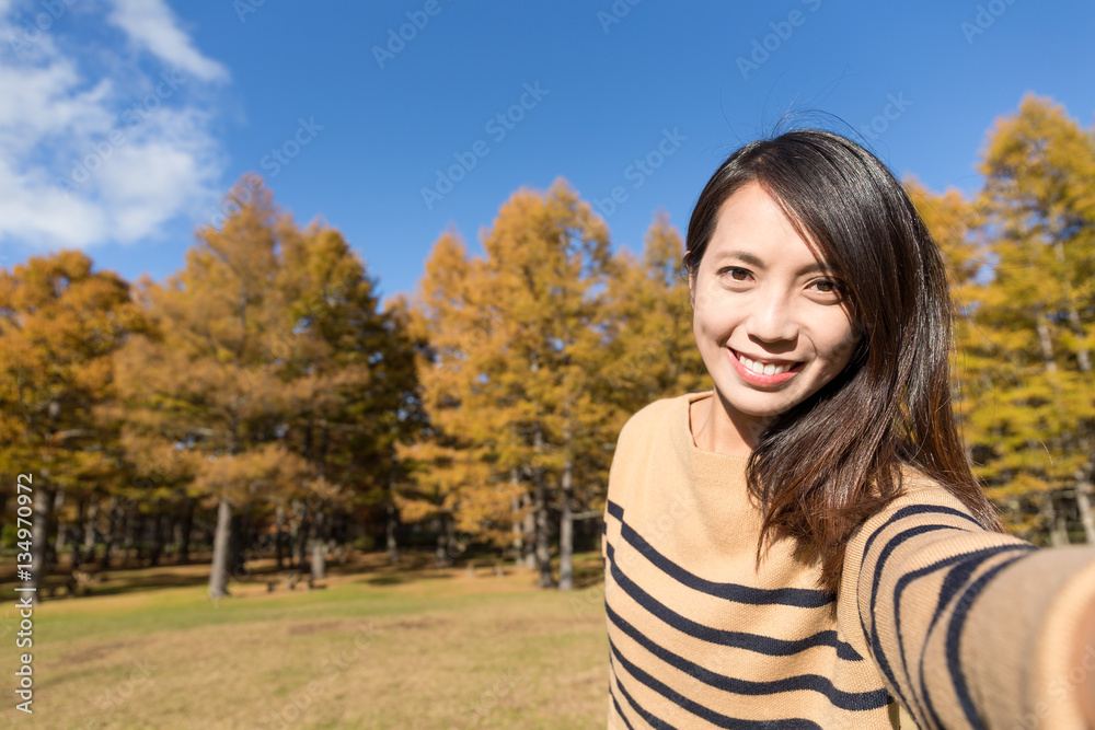 Woman holding digital camera to take selfie