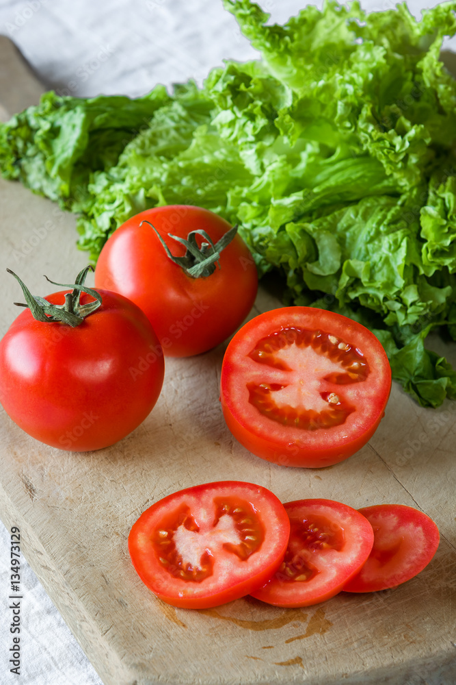Tomatoes and lettuce on a wooden background. Tomatoes and lettuce on a wooden background.