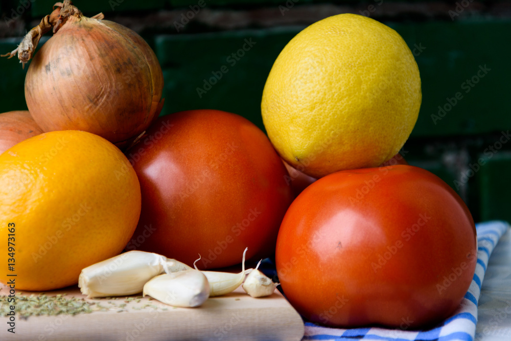 Vegetables tomato onion garlic lemon seasoning cutting board