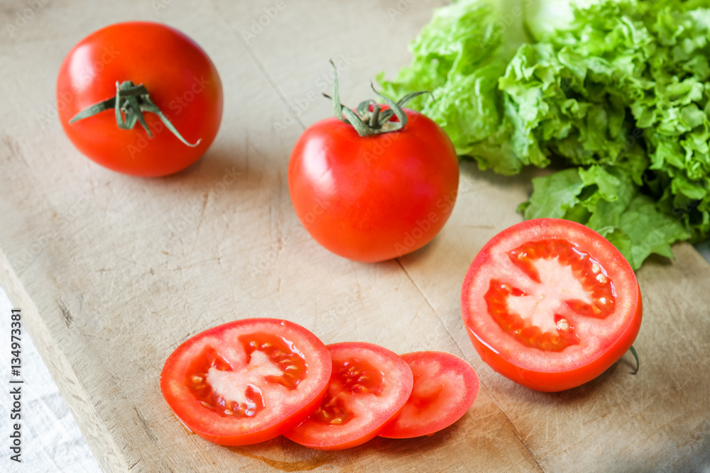 Tomatoes and lettuce on a wooden background. Tomatoes and lettuce on a wooden background.
