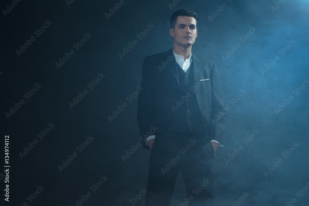 Retro 1920s english stylish gangster wearing suit standing in sm Retro 1920s english stylish gangster wearing suit standing in sm