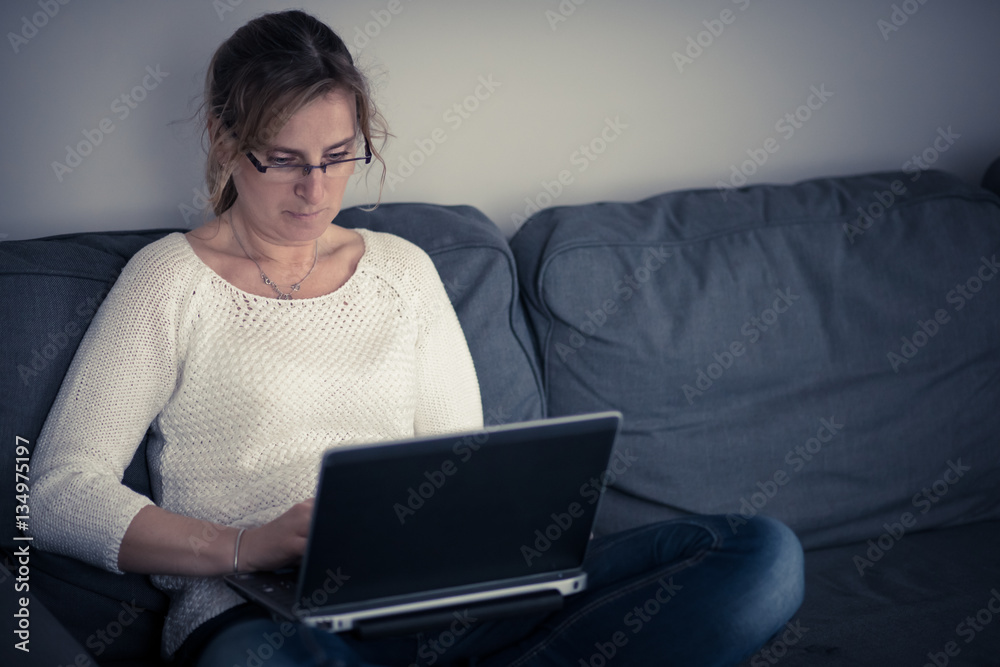 Middle-aged woman using laptop at home Middle-aged woman using laptop at home