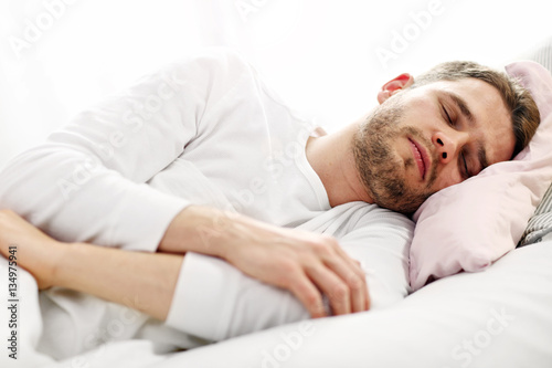 Young man sleeping in bed