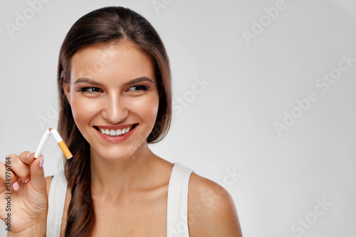 Quit Smoking. Beautiful Happy Woman Holding Broken Cigarette photo