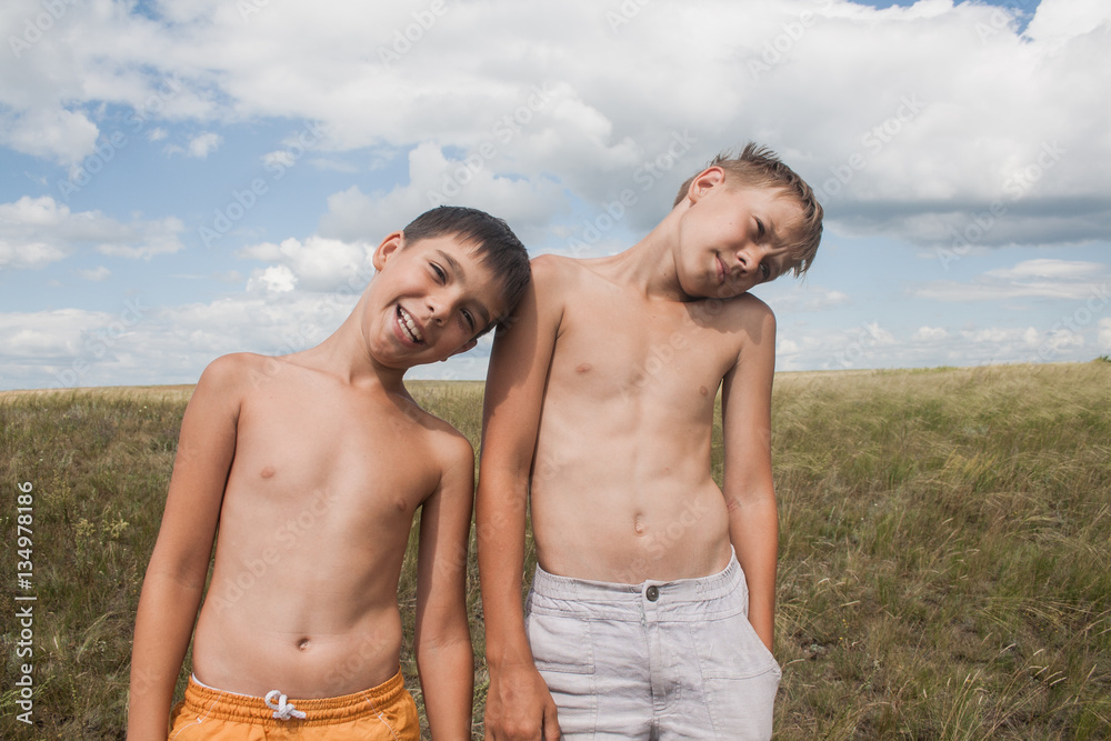 young boys standing in a field. boys in shorts. Boys stand in the desert. feather in the field. boy looking up at the sky. dreamer. two brothers. two friends. children playing in the field. young boys standing in a field. boys in shorts. Boys stand in the desert. feather in the field. boy looking up at the sky. dreamer. two brothers. two friends. children playing in the field.