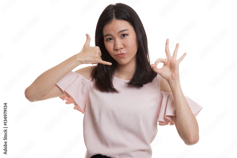 Young Asian woman show with phone gesture and OK sign. Young Asian woman show with phone gesture and OK sign.