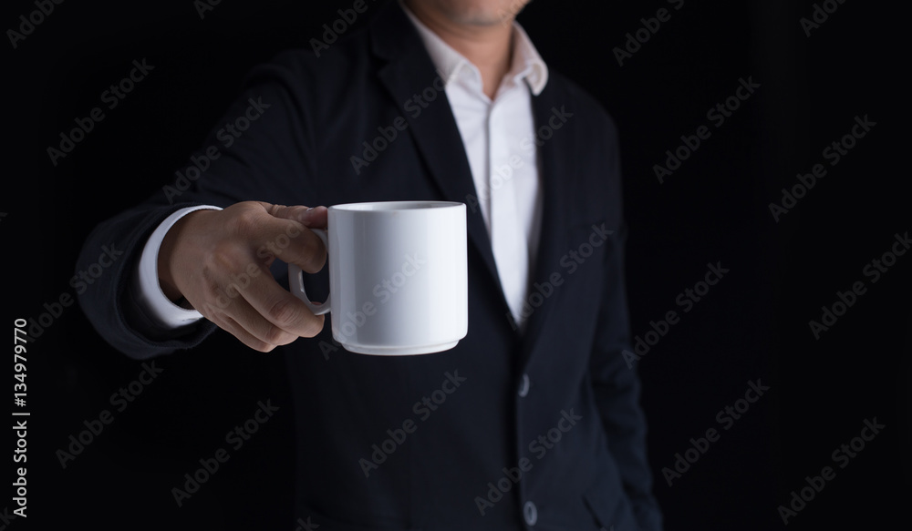 A business man in casual black suit holding a cup of coffee. A business man in casual black suit holding a cup of coffee.
