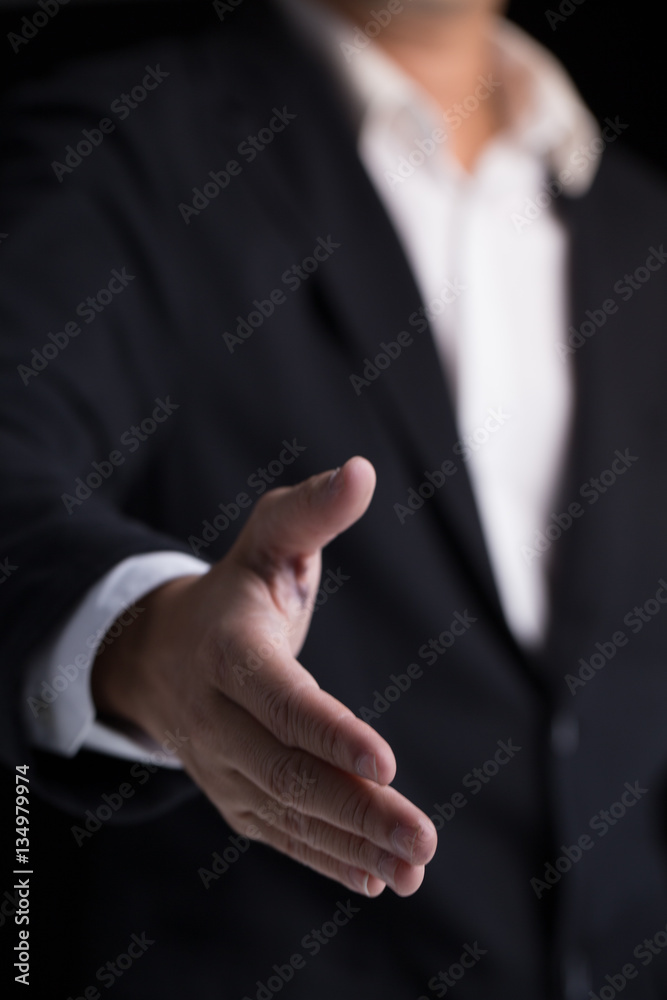 A business man wearing black suit giving one hand for shaking in cooperate look.