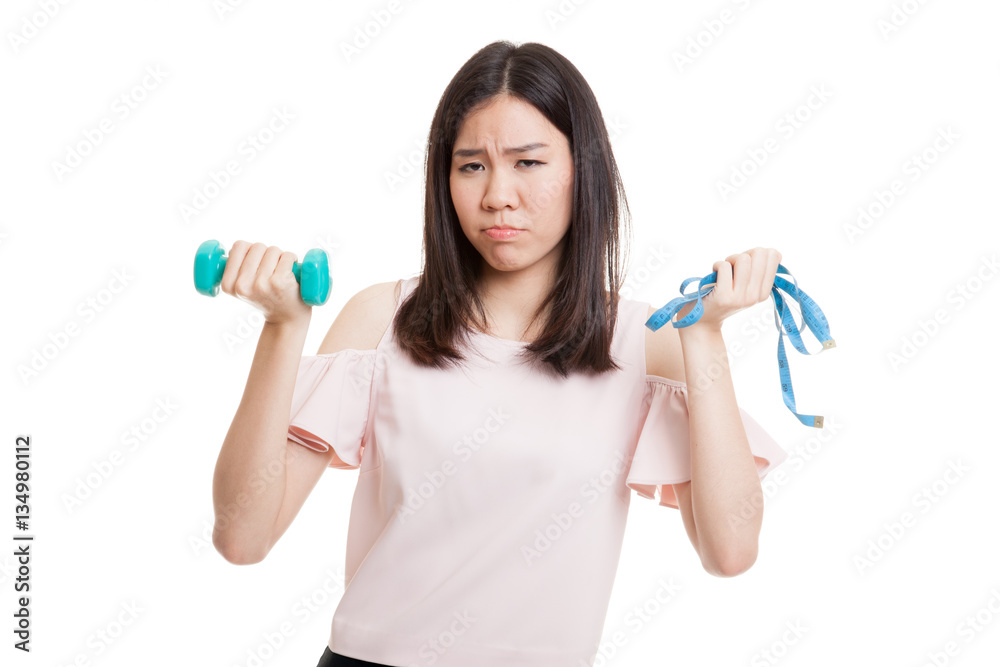 Exhausted Asian woman with dumbbells and measuring tape. Exhausted Asian woman with dumbbells and measuring tape.