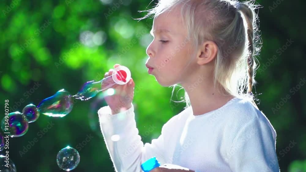 Little girl with soap bubbles in park Little girl with soap bubbles in park