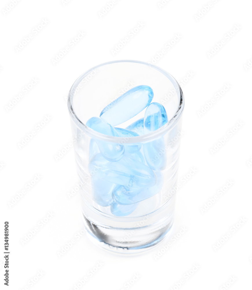 Shot glass full of softgel pills isolated Shot glass full of softgel pills isolated