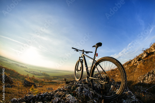 Fototapeta Naklejka Na Ścianę i Meble -  Bicycle silhouettes with blue sky on the mound