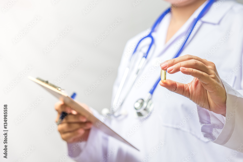 Close up of doctor hands holding medicine pill on white backgrou Close up of doctor hands holding medicine pill on white backgrou