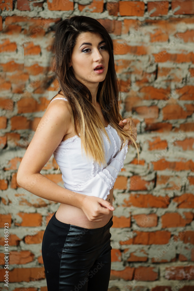 Portrait of young cute brunette girl background brick wall. Portrait of young cute brunette girl background brick wall.