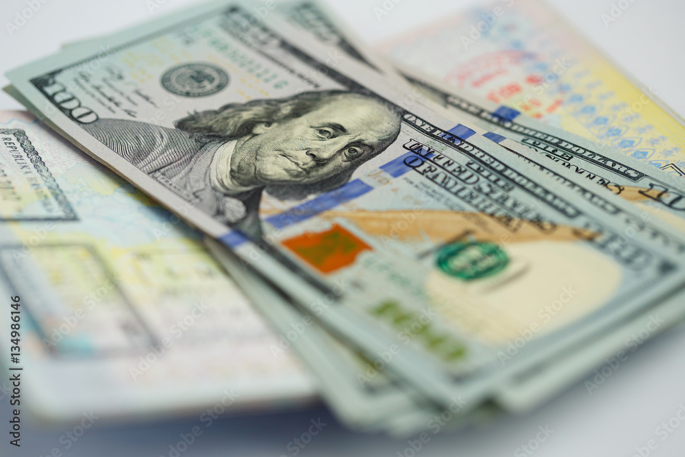 American money is on the top of the opened passport American money is on the top of the opened passport