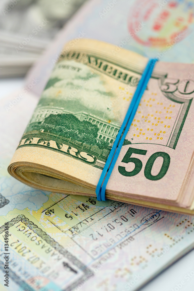 American money is on the top of the opened passport American money is on the top of the opened passport