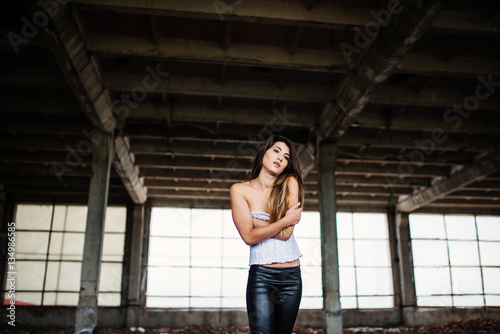 Portrait of young cute brunette girl wearing on black leather pa