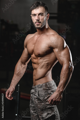 Strong and handsome athletic young man muscles abs and biceps.