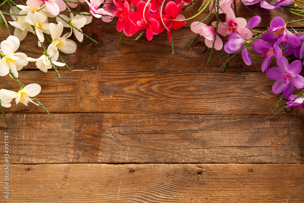 Wooden background with colorful flowers with free space for text. Concept of spring.