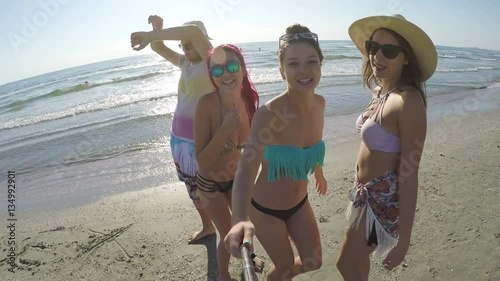 Group of friends having a selfie and partying on the beach