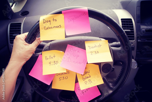 Steering wheel covered in notes as a reminder of errands to do