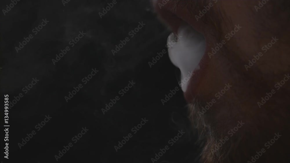 Man blows huge cloud of cigar or weed smoke or vape smoke in slow motion macro Man blows huge cloud of cigar or weed smoke or vape smoke in slow motion macro