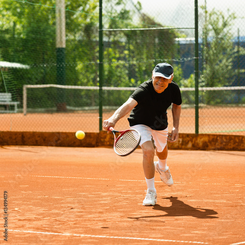 Senior male on tennis court © Microgen