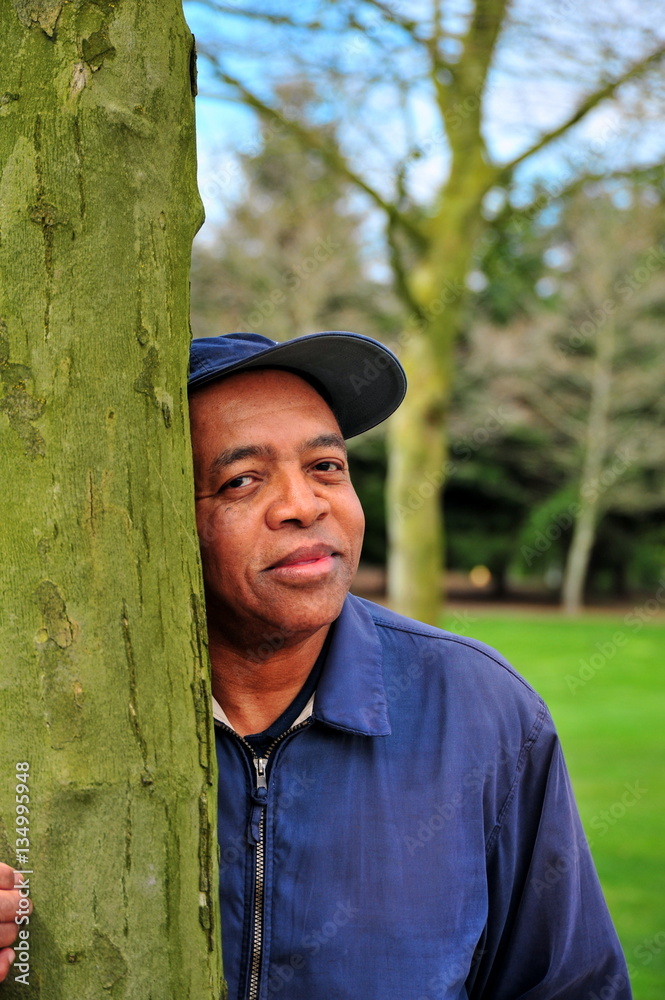 Obraz premium African american male standing next to a tree outside.
