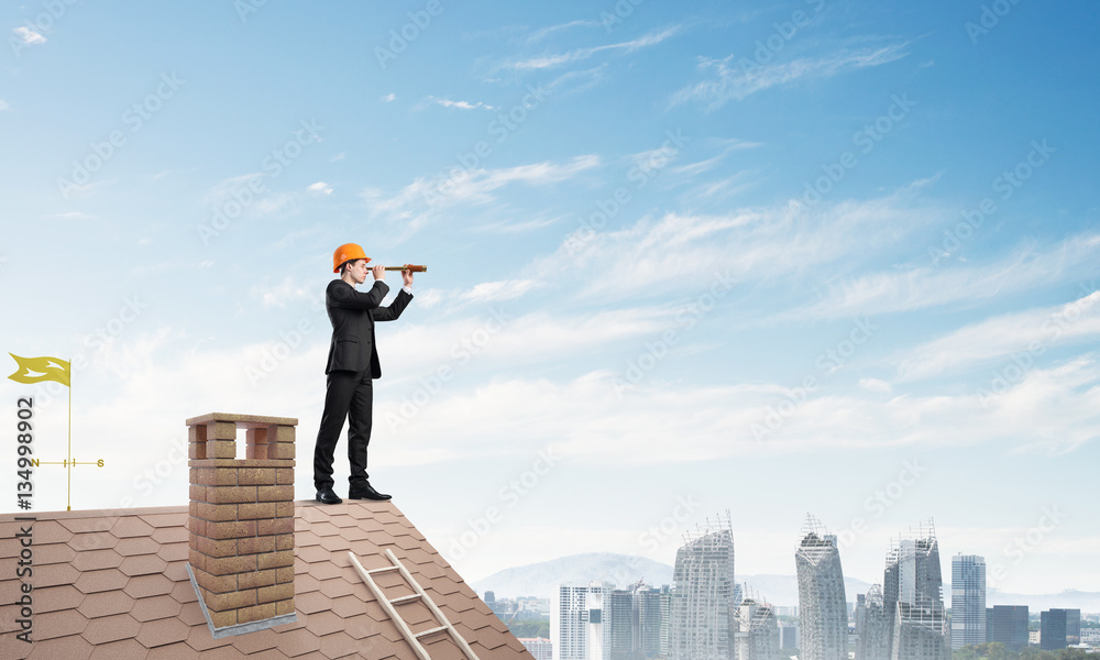 Engineer man standing on roof and looking in spyglass. Mixed media Engineer man standing on roof and looking in spyglass. Mixed media