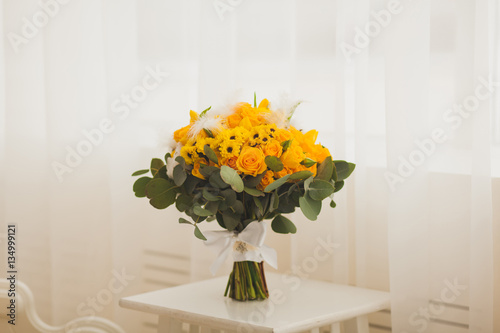 bouquet of yellow flowers standing on a chair. wedding
