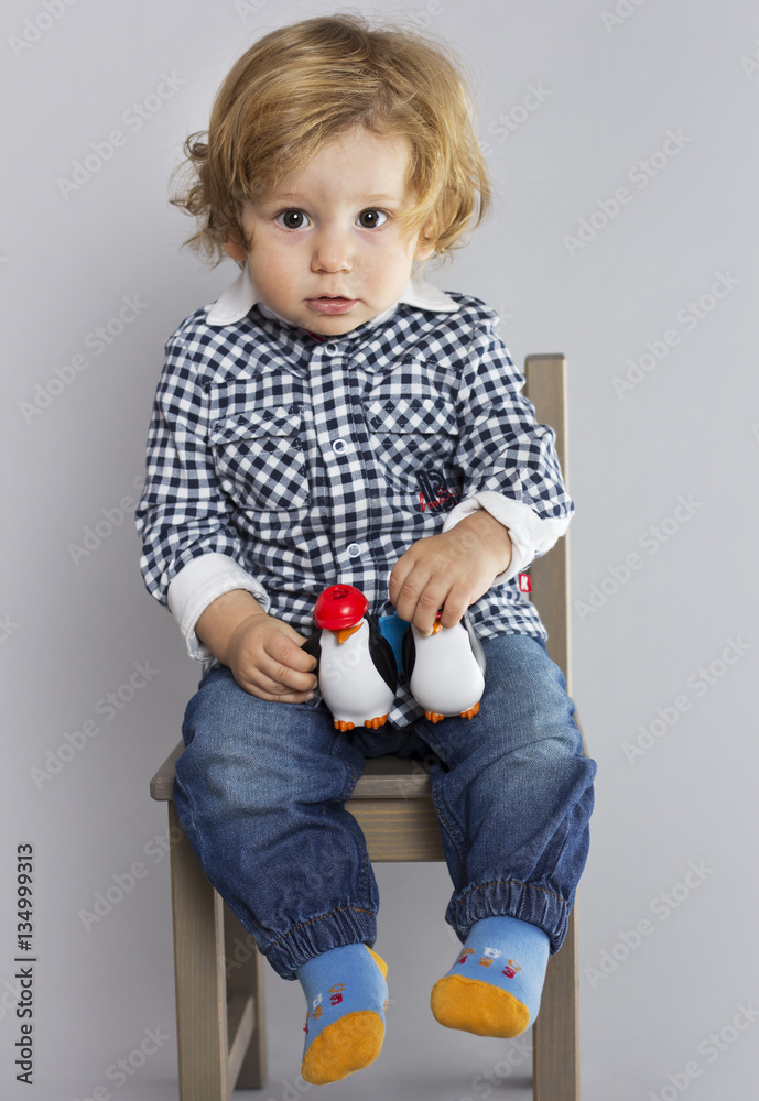 Kid with binoculars child in hands on a gray background. Boy playing. A child with toys.
Kid with binoculars child in hands on a gray background. Boy playing. A child with toys.