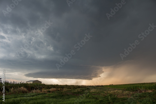 A picturesque supercell thunderstorm spins over the high plains of eastern Colorado, dropping hail and curtains of rain as it approaches.