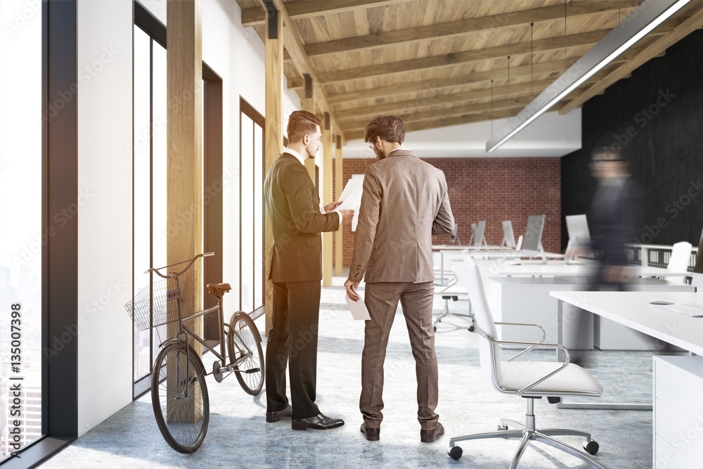 Fototapeta premium Two men in office with a poster and a bike
