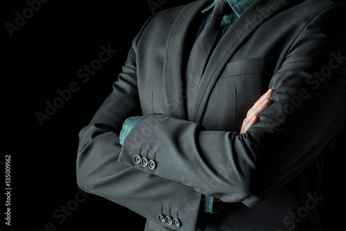 Fotografie Businessman standing with folded arms in a classic black suit