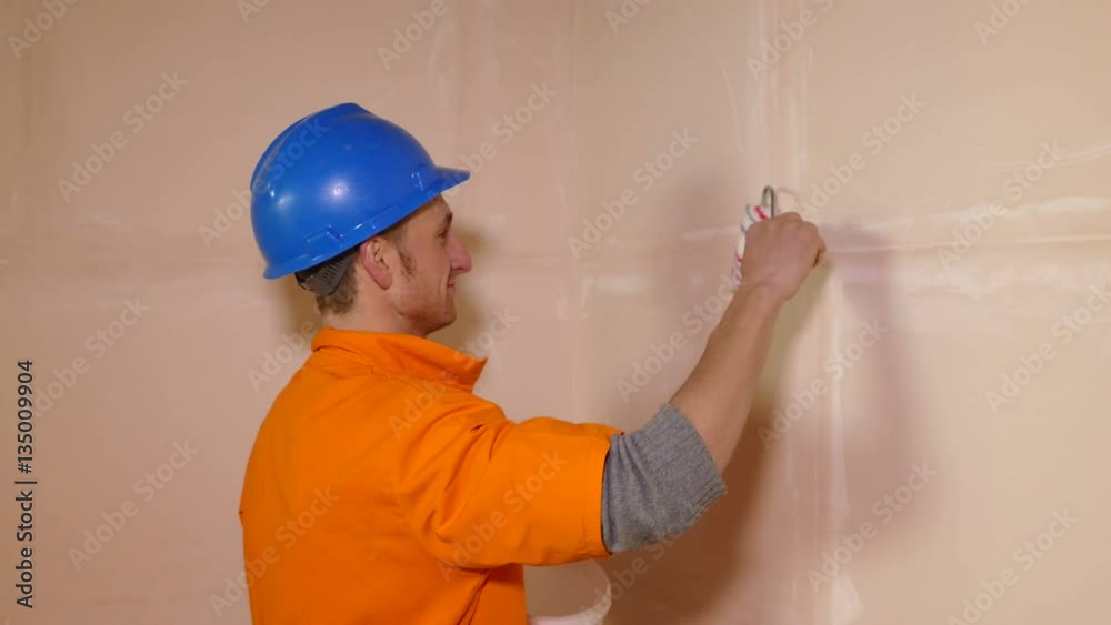 Young worker working with paint roller Young worker working with paint roller