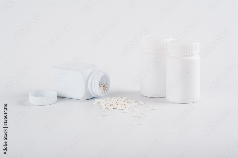 Pills spilling out of pill bottle on white background. view with copy space. Medicine concept Pills spilling out of pill bottle on white background. view with copy space. Medicine concept