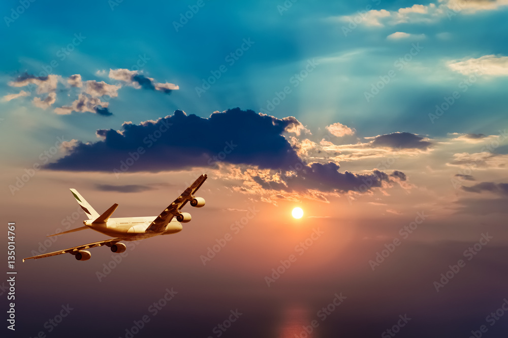 Fototapeta Samolot lecący w stronę pięknego zachodu słońca