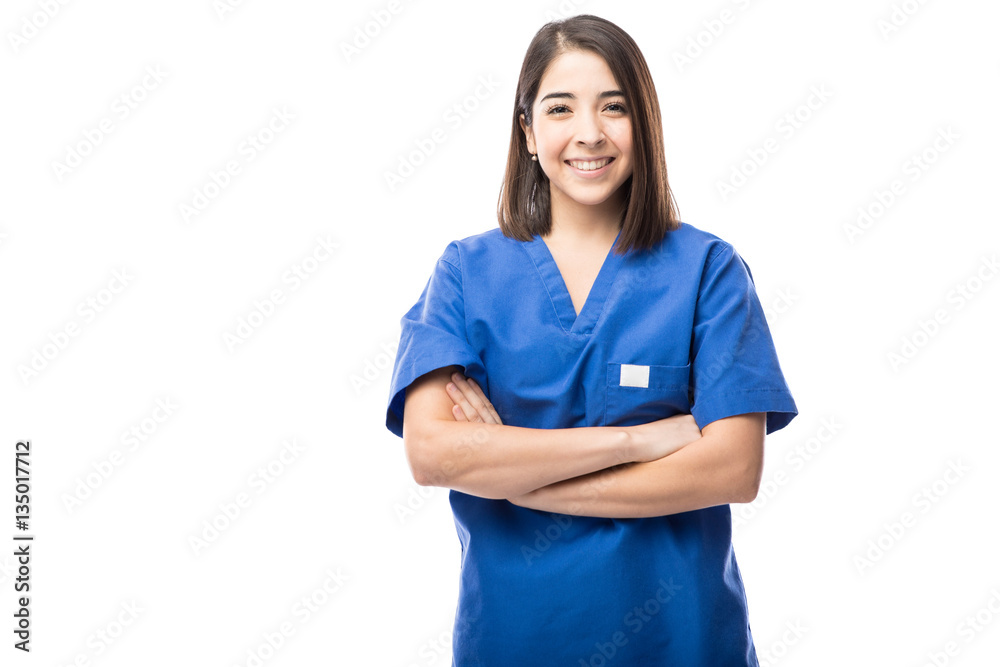 Young nurse with arms crossed wearing scrubs in a studio Young nurse with arms crossed wearing scrubs in a studio