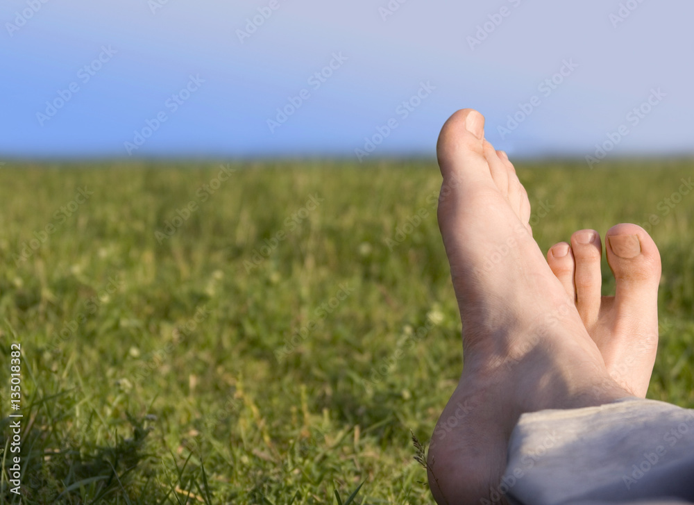 bare feet resting on grass in summer men sunny day in spring bare feet resting on grass in summer men sunny day in spring